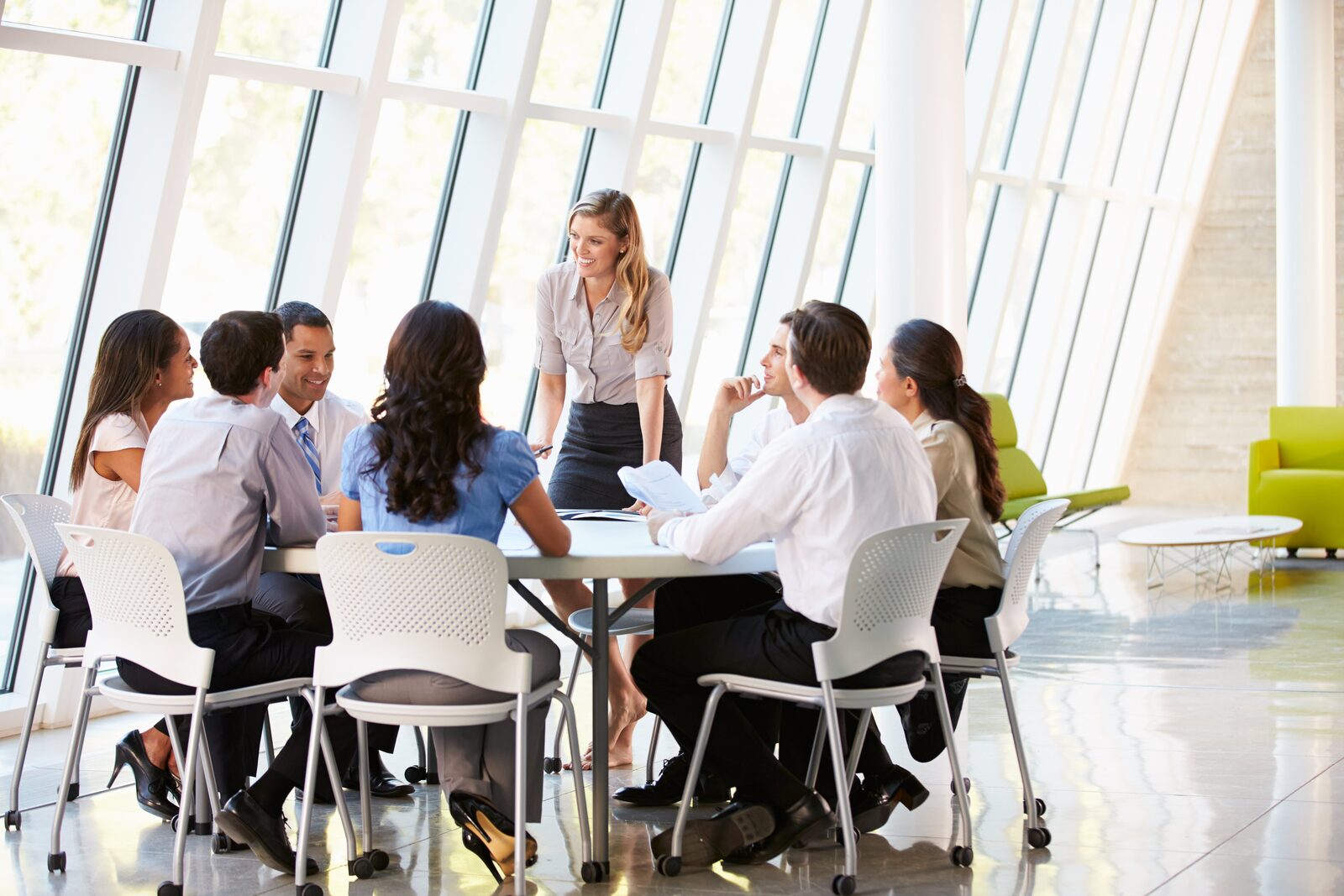Professionals working together around tables in a bright training room