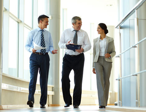 Colleagues walking and talking through an office corridor